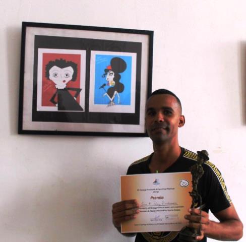 LUIS ENRIQUE PEREZ. PRIMER PREMIO SALON NACIONAL HUMORISMO. AL FONDO LA OBRA GALARDONADA